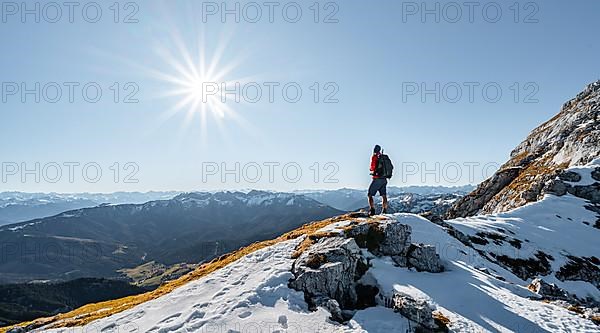 Climbers on the rocky summit ridge with first snow in autumn