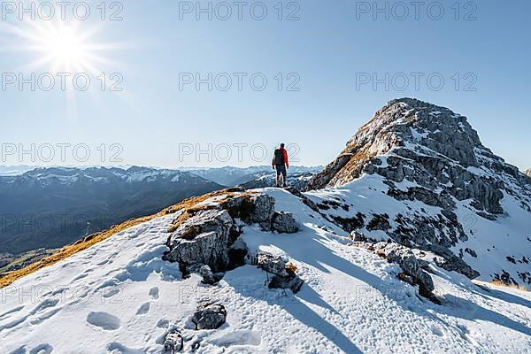 Climbers on the rocky summit ridge with first snow in autumn