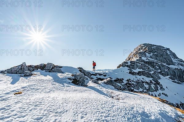 Climbers on the rocky summit ridge with first snow in autumn