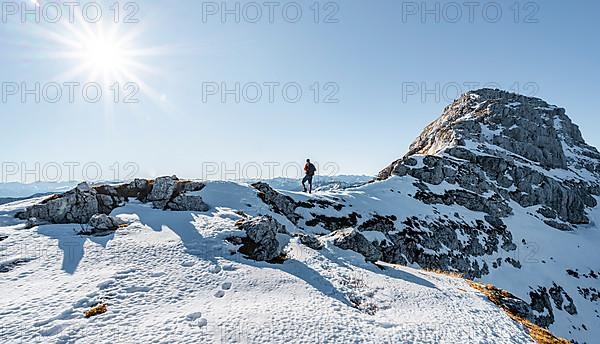 Climbers on the rocky summit ridge with first snow in autumn