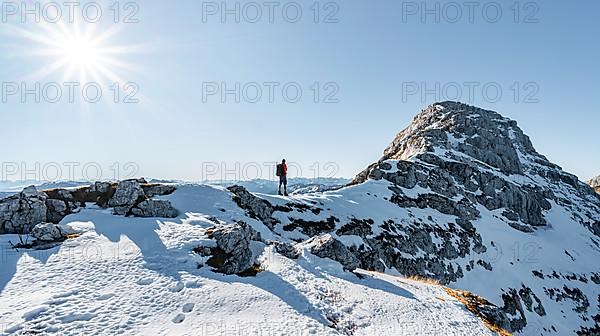 Climbers on the rocky summit ridge with first snow in autumn