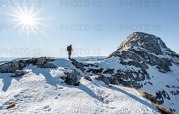 Climbers on the rocky summit ridge with first snow in autumn