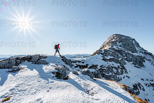 Climbers on the rocky summit ridge with first snow in autumn