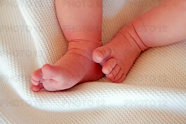 Baby girls feet on a white blanket