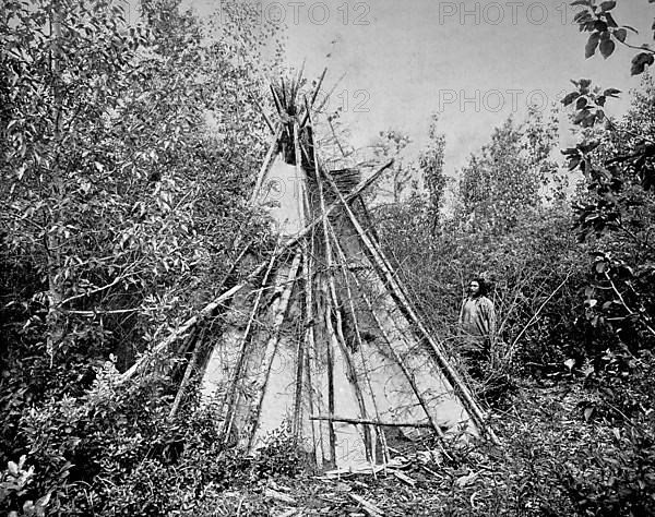 Crow or Absaroka Indian Chief standing in front of the tent of his woman's funeral court