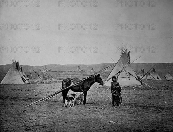 An Indian woman with her Indian pony in front of the tipis of an Indian village in the Alberta region