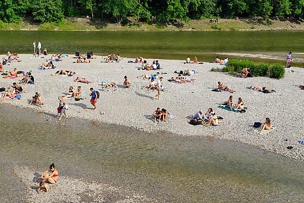 People bathing on a gravel bank in the Isar river