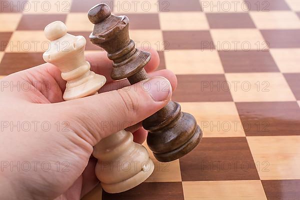 Person playing chess game making a move on board