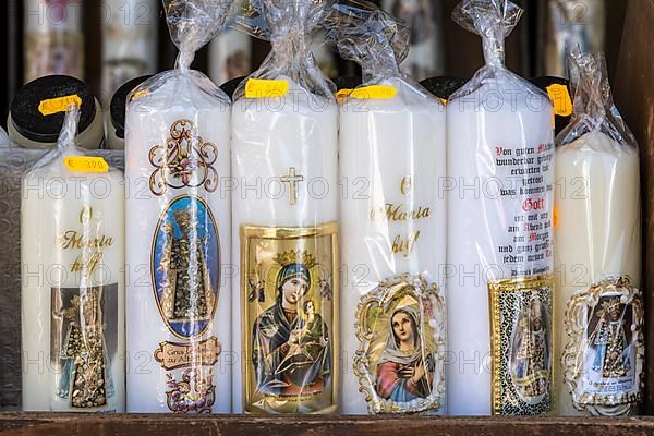 Candles with images of Mary and the saints in front of a devotional shop at Kapellplatz