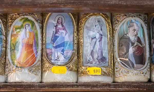 Candles with images of Mary and the saints in front of a devotional shop at Kapellplatz