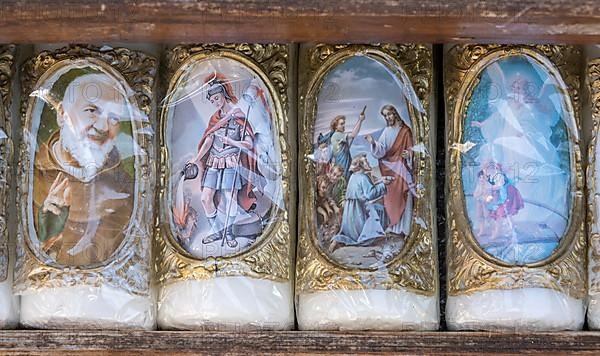 Candles with images of Mary and the saints in front of a devotional shop at Kapellplatz