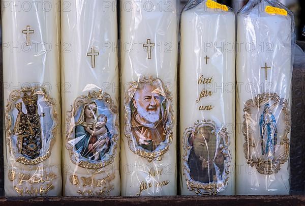 Candles with images of Mary and the saints in front of a devotional shop at Kapellplatz