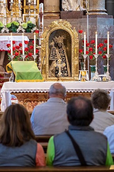 Worshippers sit in front of the Black Madonna in the collegiate parish church of St. Philip and St. James in the pilgrimage town of Altoetting. The image of grace is normally in the Holy Chapel