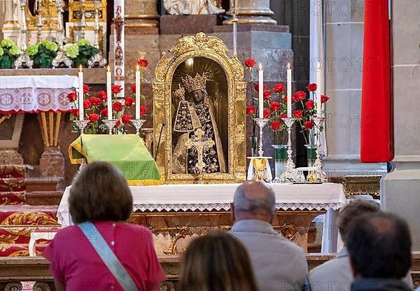 Worshippers sit in front of the Black Madonna in the collegiate parish church of St. Philip and St. James in the pilgrimage town of Altoetting. The image of grace is normally in the Holy Chapel