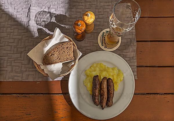 Bratwurst served with potato salad and bread in an inn