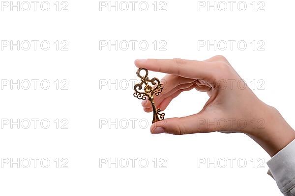 Hand holding a retro styled metal key on a white background