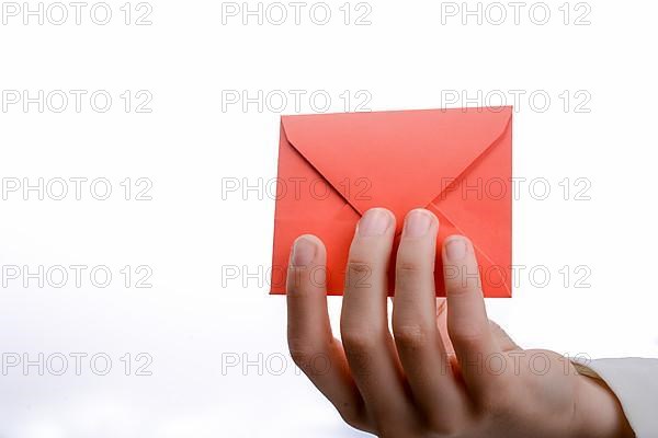 Hand holding a red envelope on a white background