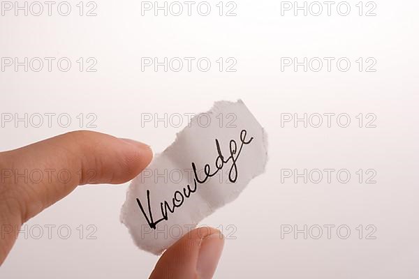 Knowledge written torn paper on a white background