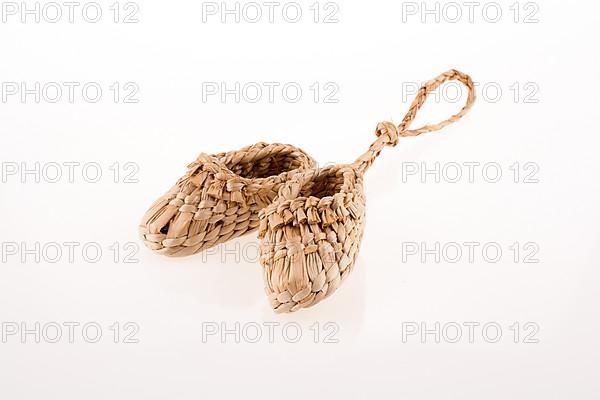 Pair of footware made of straw on white background
