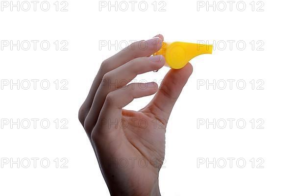 Hand holding a yellow whistle on a white background