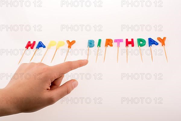 Hand and color candles on sticks write the words happy birthday