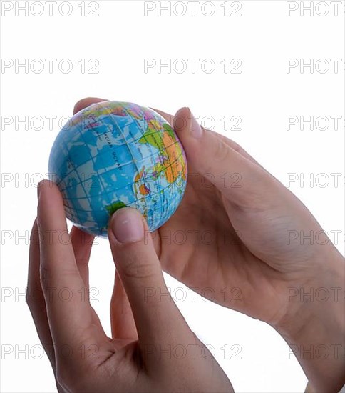 Child holding a small globe in hand on white background