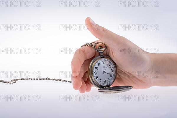 Hand holding a retro styled pocket watch in hand