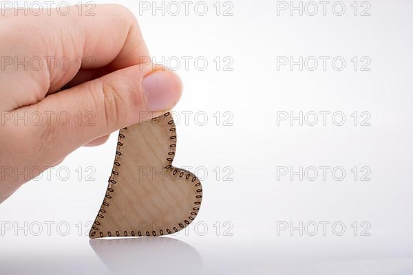 Heart shaped wooden object in the hand
