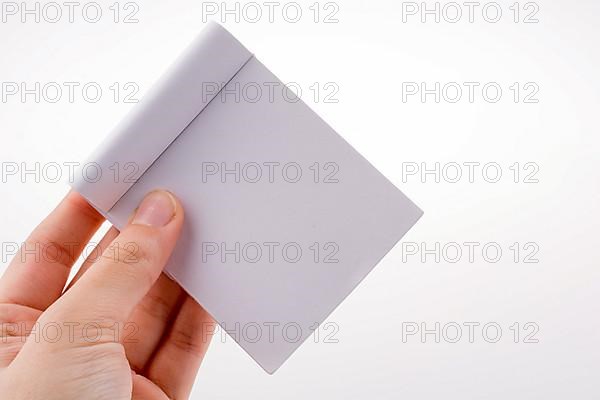 White little notebook in hand on a white background