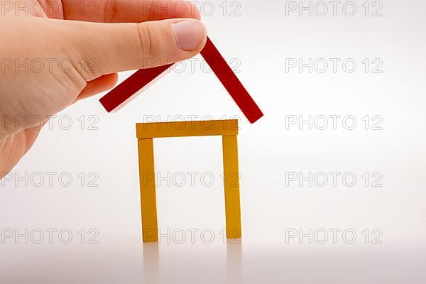 Hand holding domino pieces forming a house shape