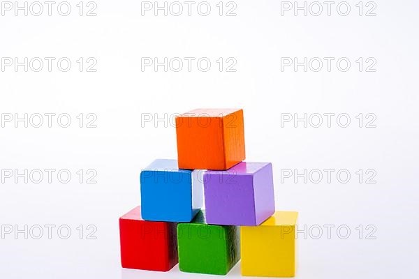 Hand playing with colorful cubes on a white background