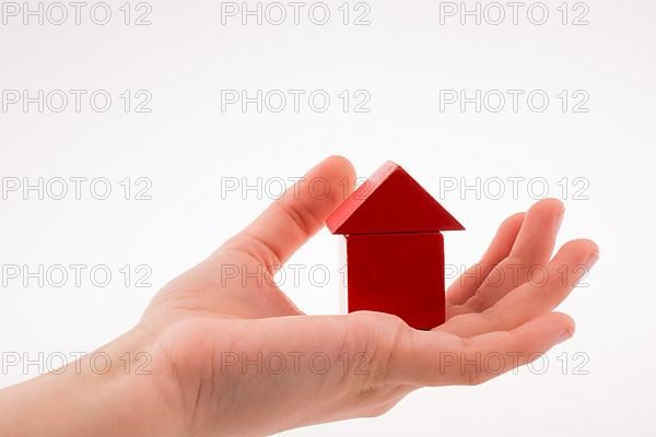 House made of colorful cubes in hand on a white background