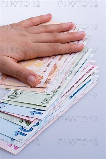 Hand holding Turksh Lira banknotes on white background