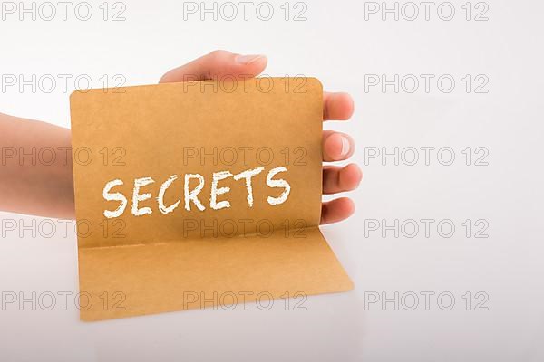 Hand holding a sheet of paper on a white background