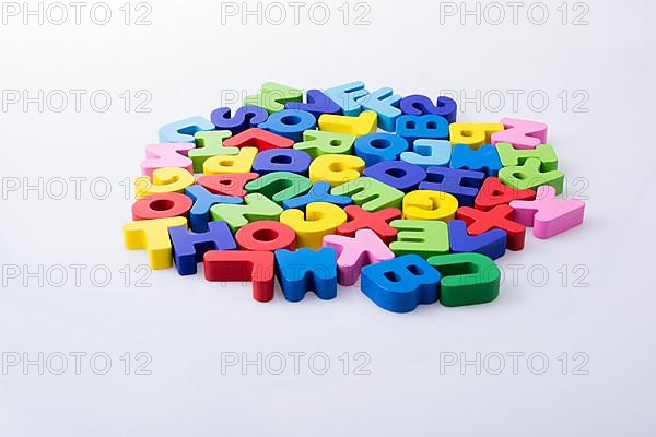 Colorful alphabet letter blocks scattered randomly on white background