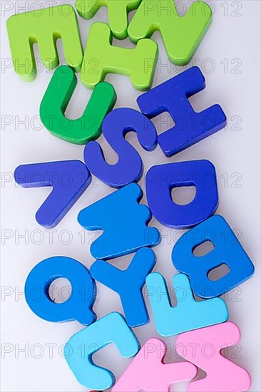 Colorful alphabet letter blocks scattered randomly on white background