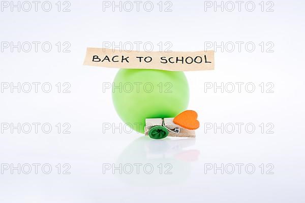 Clothespin with a heart and a balloon on white background