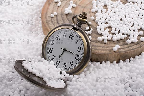 Retro pocket watch on white polystyrene balls