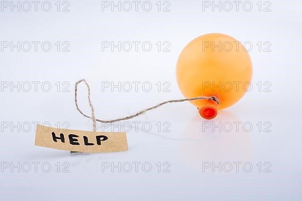 Help word written paper attached to a balloon with a string