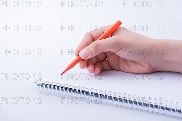 Hand writing on a Notebook with a pen on a white background