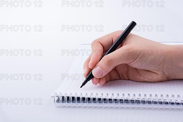 Hand writing on a Notebook with a pen on a white background