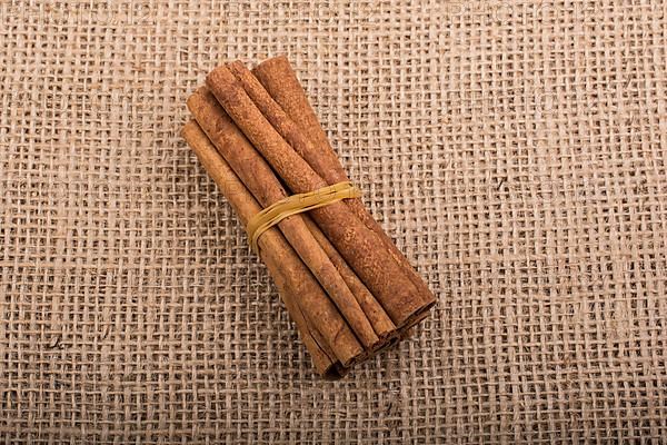 Bundle of cinnamon sticks on a linen canvas background