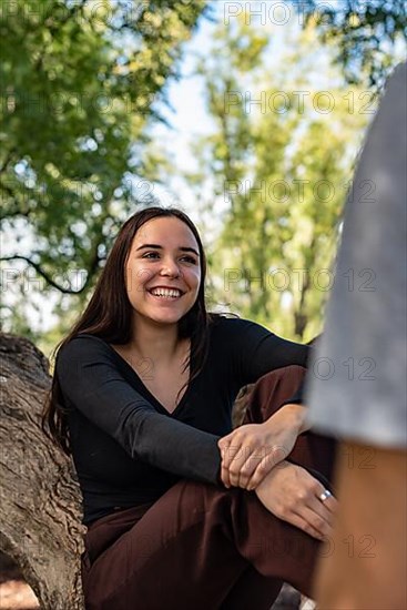 Young man takes the hand of a beautiful girl asking her to go with him. She laughs and seems to be happy