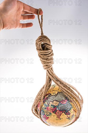 Globe hanging in rope on white background