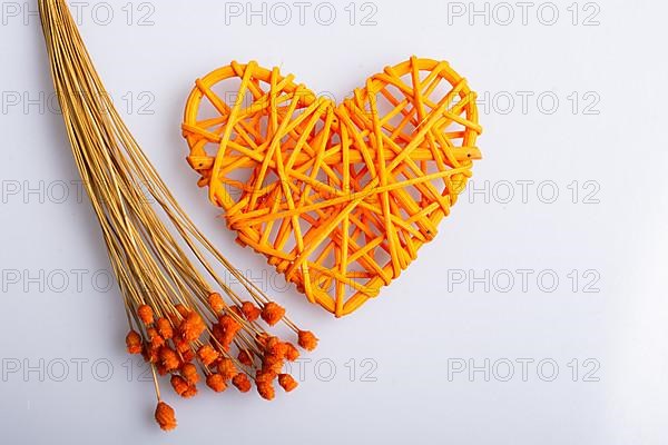 Bunch of dried flower and heart on white background