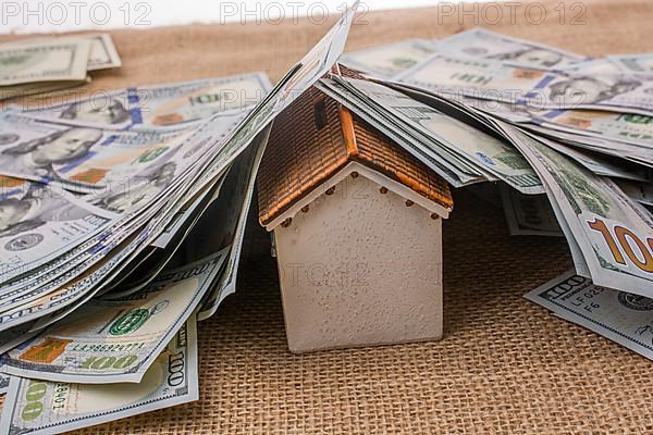 Model house is covered by banknotes of US dollars