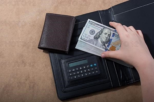 Hand holding American dollar banknotes isolated on wooden background