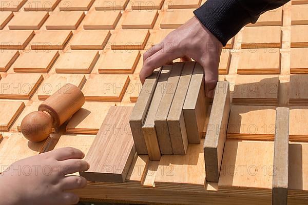 Hand holding wooden puzzle element in hand