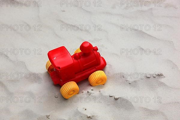 Colourful plastic children's toys in a sandbox