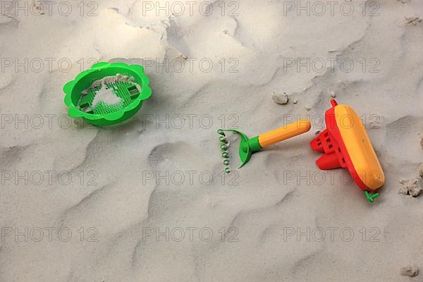 Colourful plastic children's toys in a sandbox